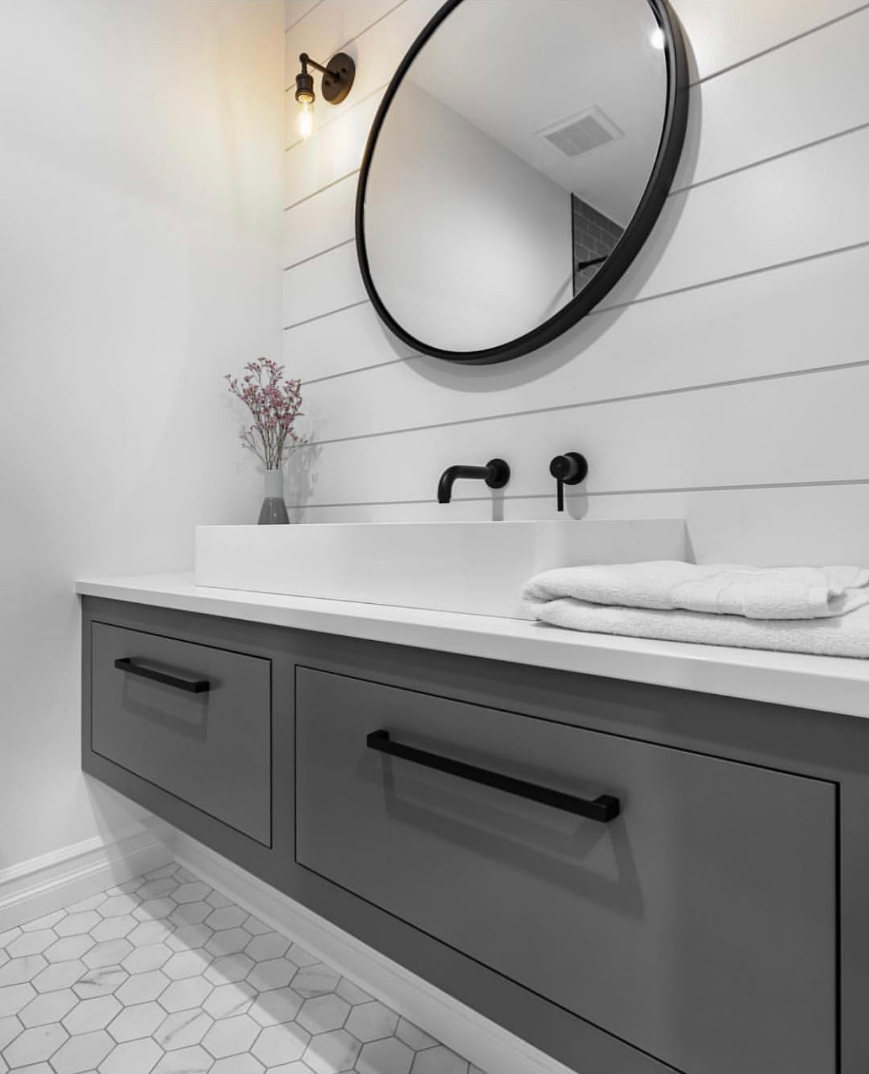 Gray vanity cabinet with panel on the wall